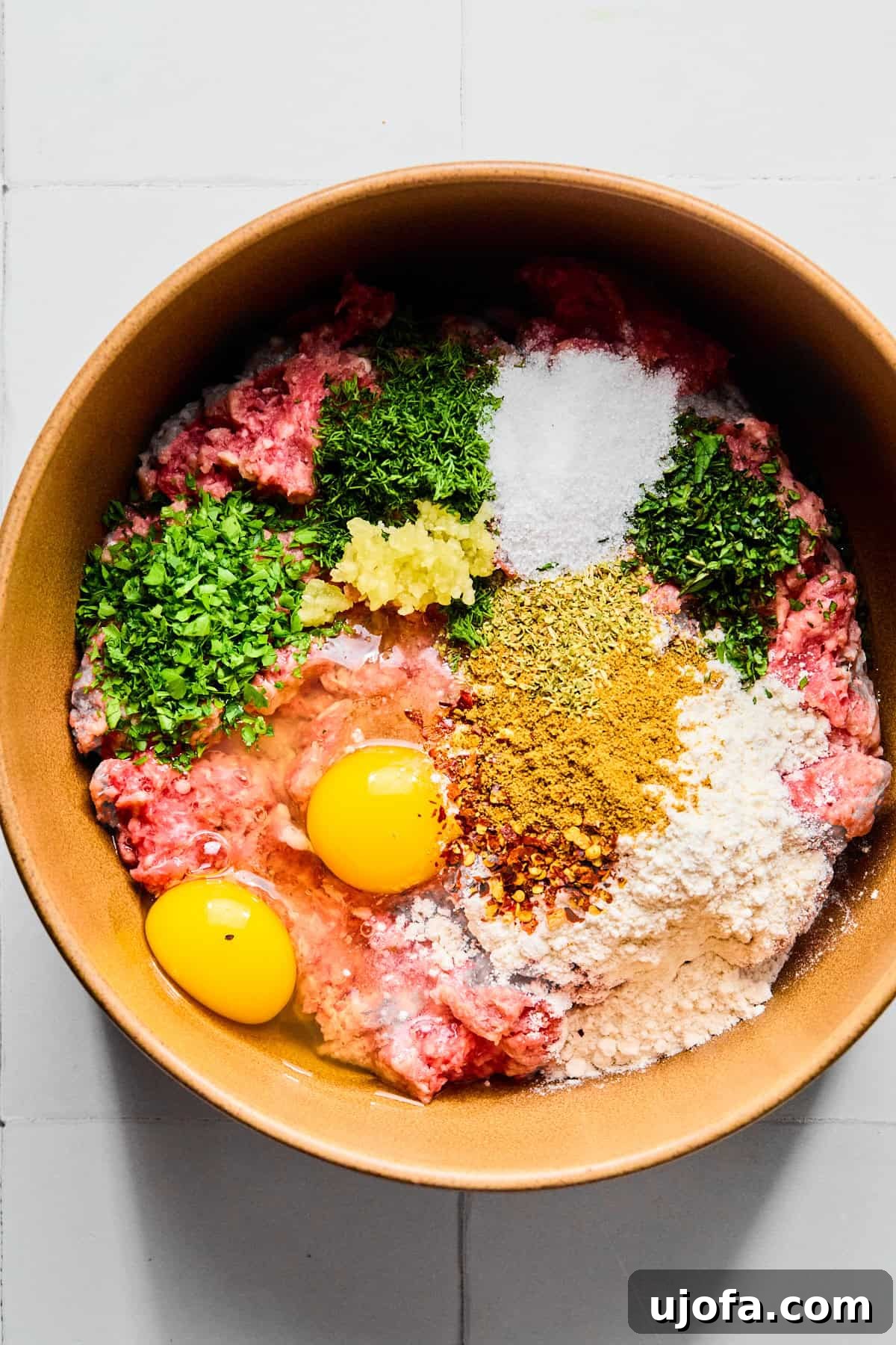 Greek lamb meatball ingredients in a large bowl.