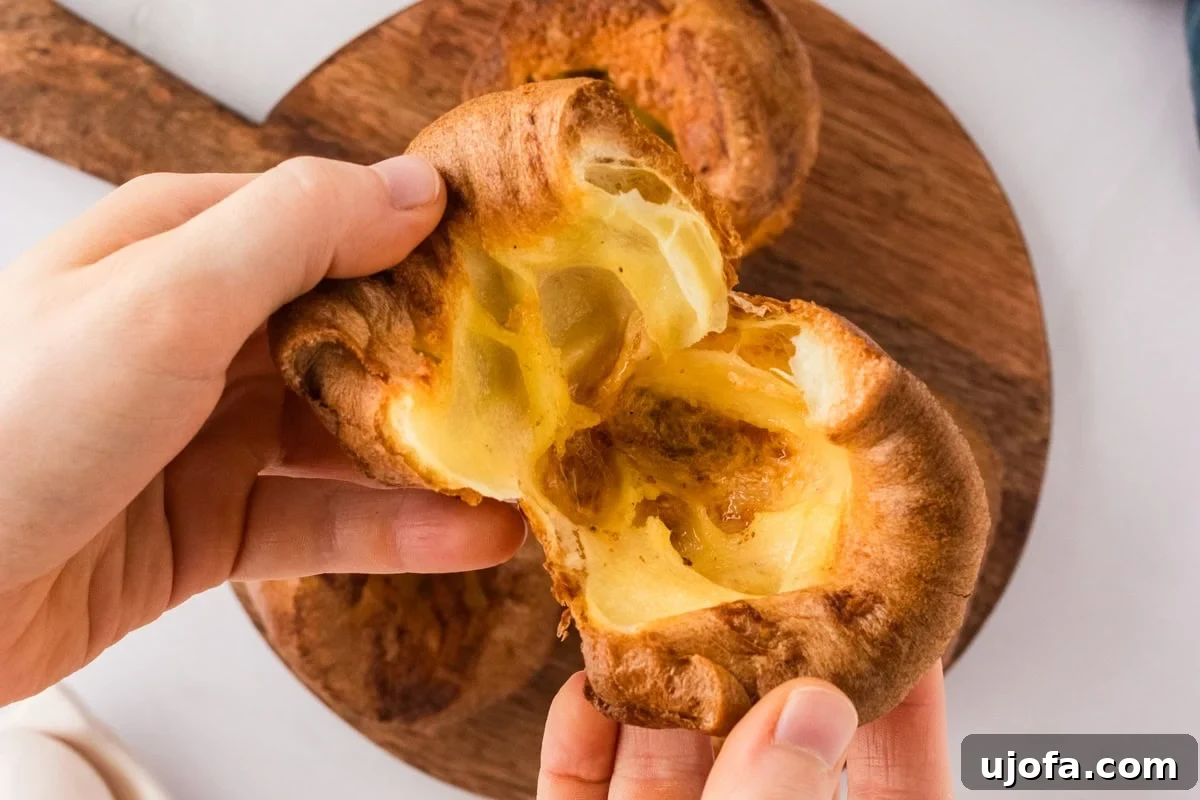 Perfect Gluten-Free Yorkshire Puddings 13 yorkshire pudding being pulled apart by two hands over wooden cutting board