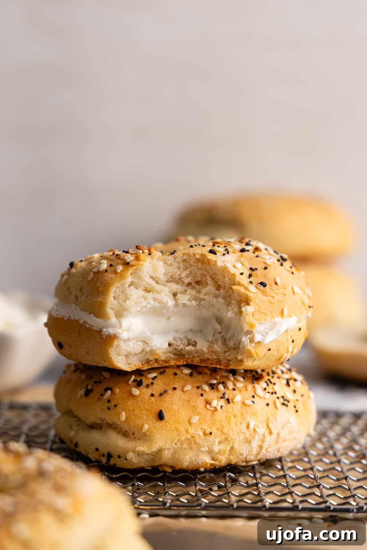 Effortless High Protein Gluten Free Cottage Cheese Bagels 8 Two cottage cheese bagels stacked on top of each other; the top one is filled with cream cheese.