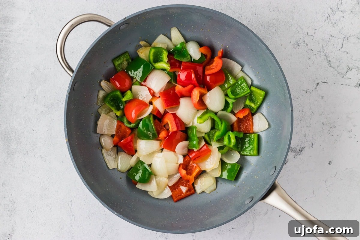 Sautéed bell peppers and onion in a wok, vibrant and tender-crisp.