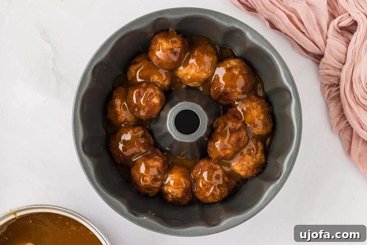 Gooey Gluten-Free Monkey Bread Indulgence 13 A bundt pan half-filled with individual gluten-free monkey bread dough balls, each coated in cinnamon sugar.