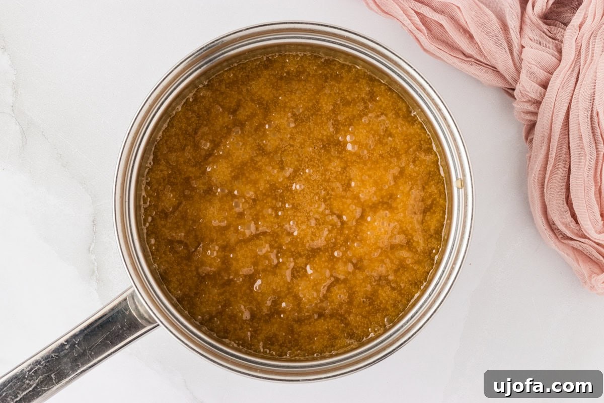Gooey Gluten-Free Monkey Bread Indulgence 9 Caramel sauce boiling vigorously in a small saucepan on the stove, bubbling and thickening.