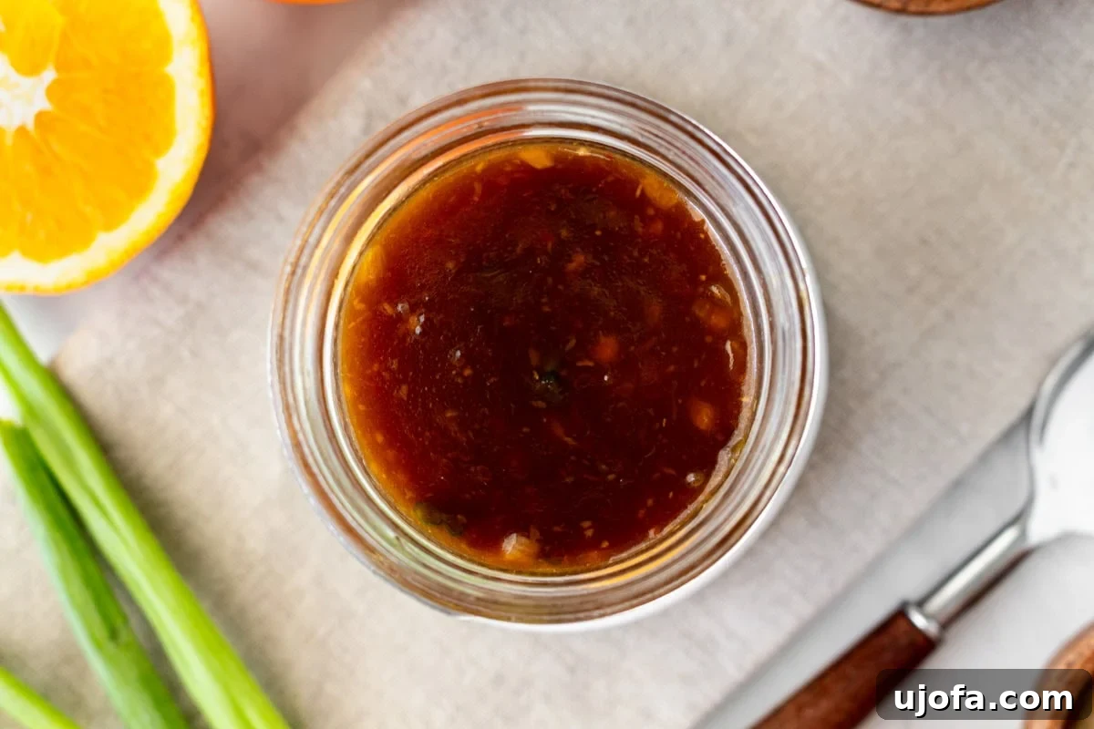 Golden Orange Reduction 13 Overhead view of a mason jar filled with finished orange reduction sauce, ready for storage or serving.