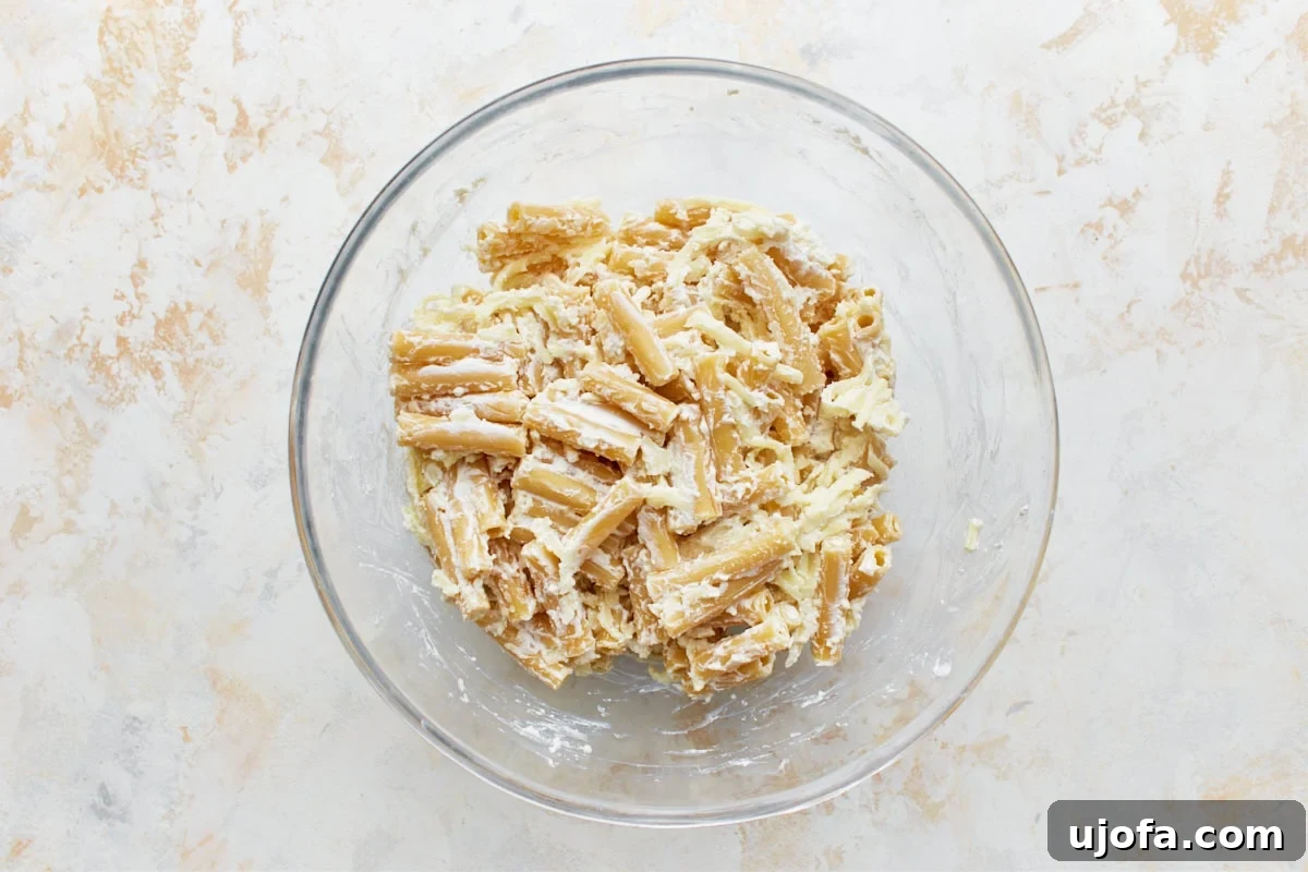 Comforting Gluten-Free Ziti Bake 10 cooked gluten-free pasta and cheese mixture in a glass bowl