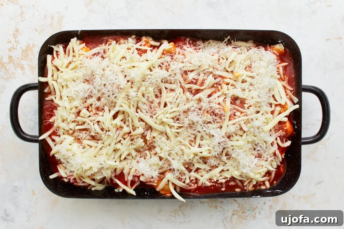 Comforting Gluten-Free Ziti Bake 13 gluten-free ziti in a black baking dish, with marinara and sprinkled with parmesan and mozzarella cheese