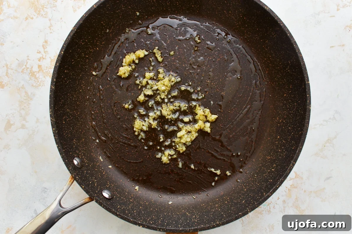 Comforting Gluten-Free Ziti Bake 8 black skillet with sautéed minced garlic and oil