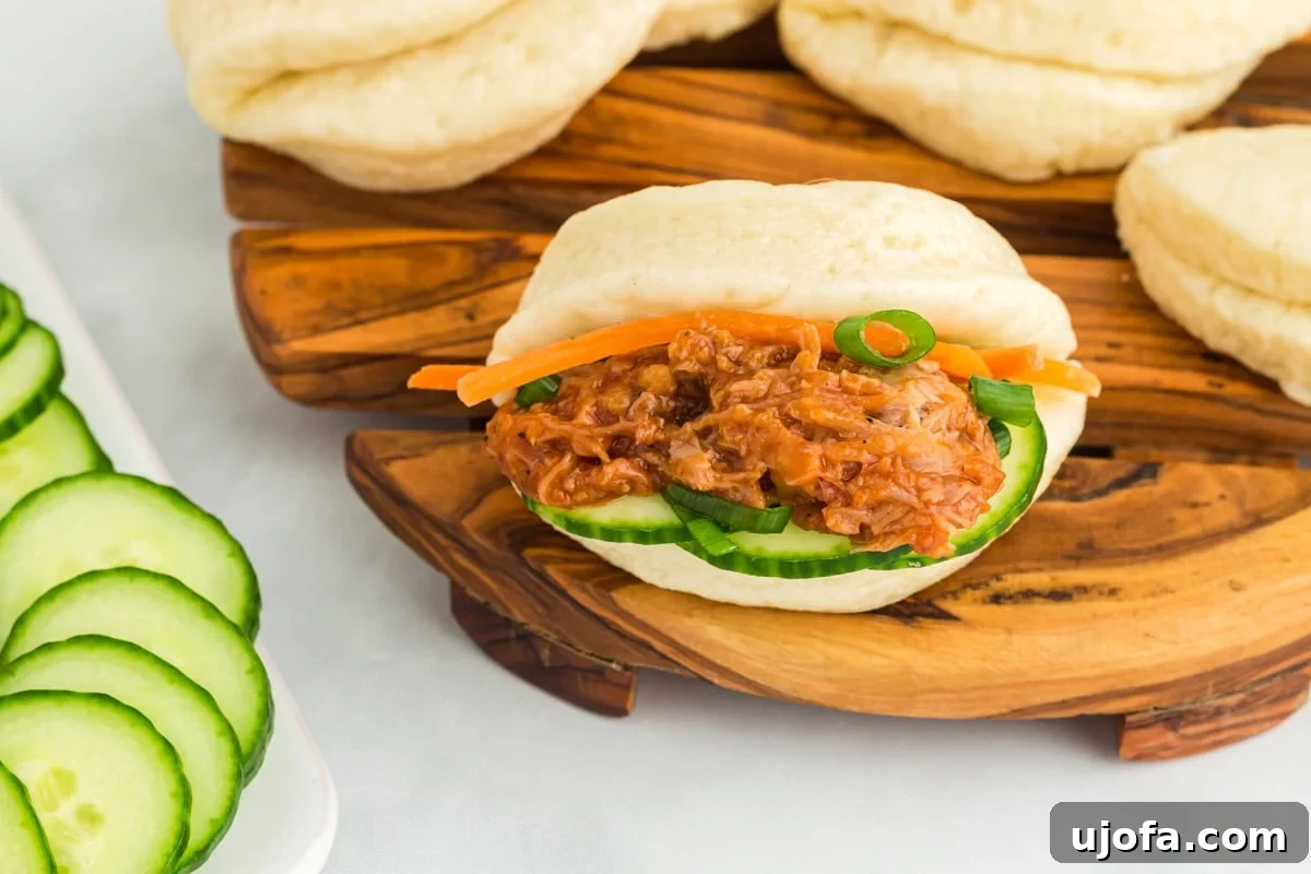 A freshly made gluten-free bao bun, beautifully filled and ready to be enjoyed, presented on a round wooden cutting board.