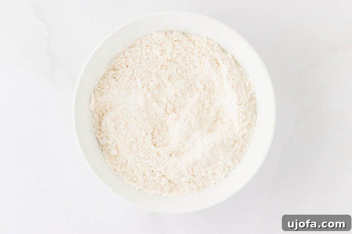 Guilt-Free Crispy Egg Rolls 11 A white bowl holding a mixture of gluten-free flour and cornstarch, prepared for making the egg roll wrappers.