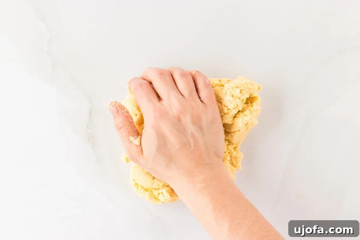 Guilt-Free Crispy Egg Rolls 14 Hands kneading a smooth, pliable ball of gluten-free egg roll dough on a clean white surface.