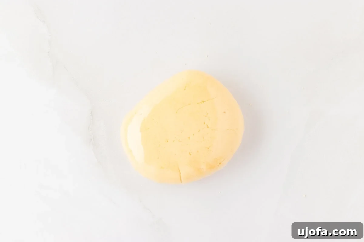 Guilt-Free Crispy Egg Rolls 15 A perfectly smooth ball of rested gluten-free egg roll dough, ready for rolling, on a white surface.