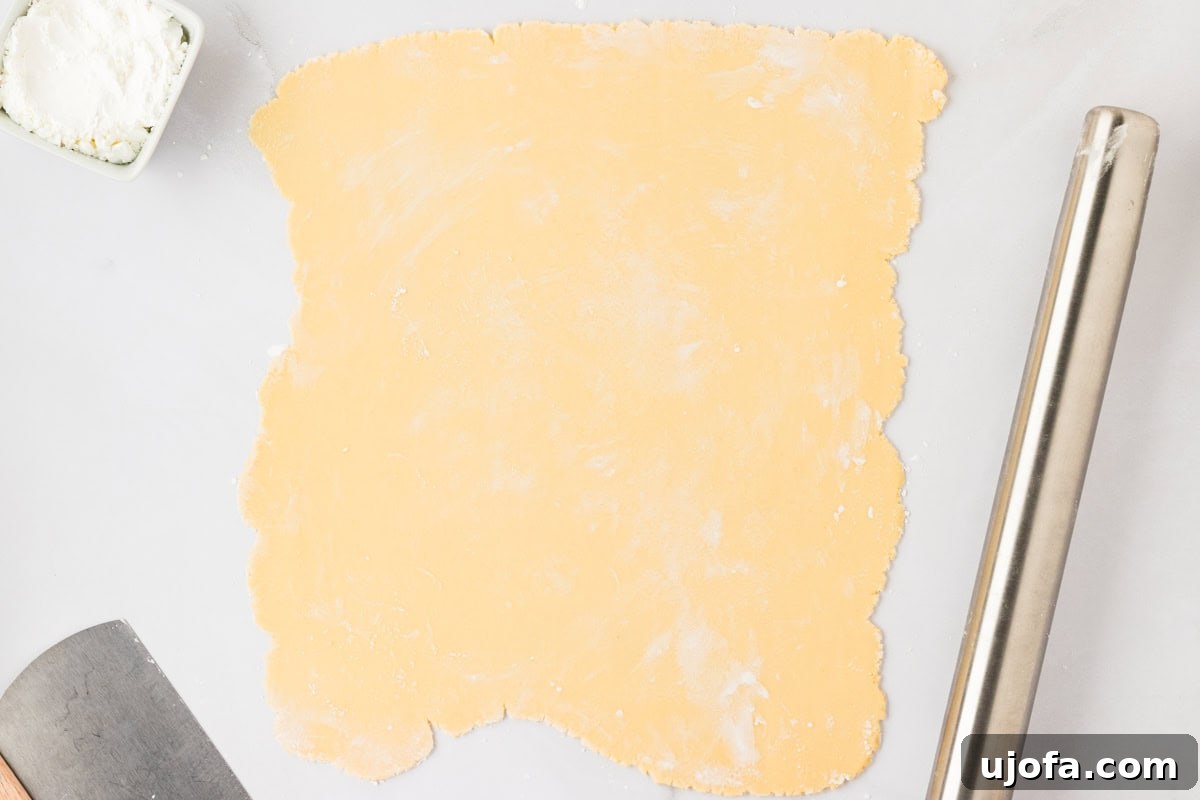 Guilt-Free Crispy Egg Rolls 17 A large rectangular sheet of thinly rolled gluten-free egg roll dough on a cornstarch-dusted surface.