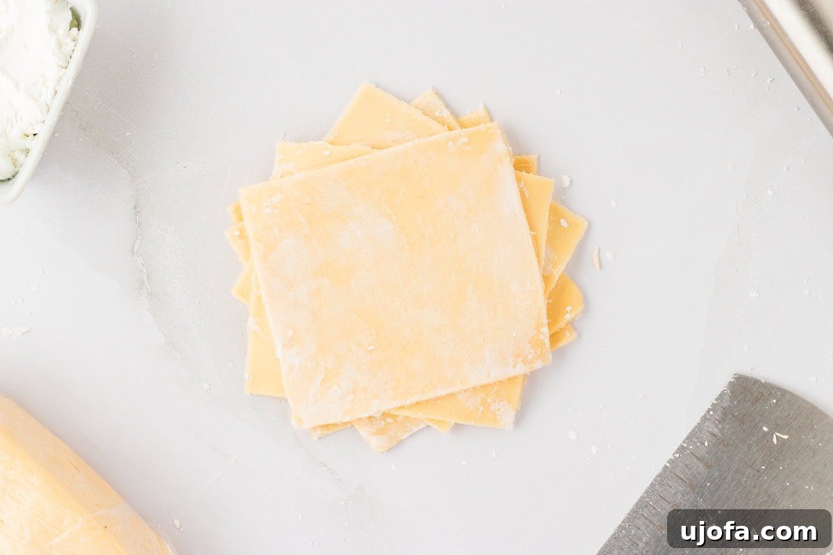 Guilt-Free Crispy Egg Rolls 18 A stack of approximately 4-inch square gluten-free egg roll dough pieces, lightly dusted with cornstarch.