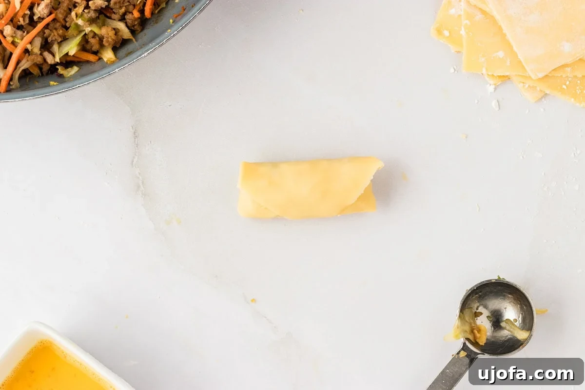 Guilt-Free Crispy Egg Rolls 25 A perfectly rolled, raw gluten-free egg roll, sealed and ready for frying.