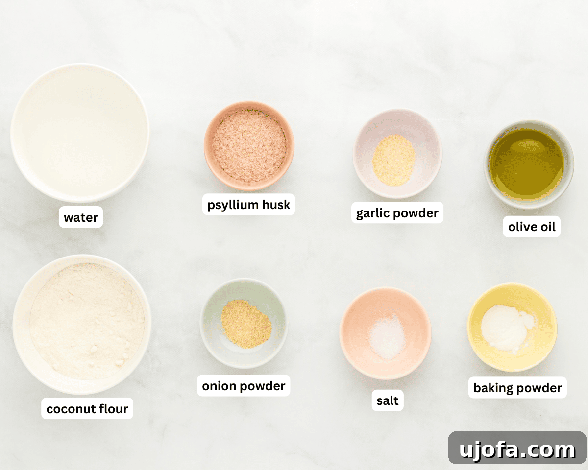 All the necessary ingredients for coconut flour tortillas laid out on a clean white surface: coconut flour, whole psyllium husk, baking powder, onion powder, garlic powder, salt, and extra virgin olive oil.