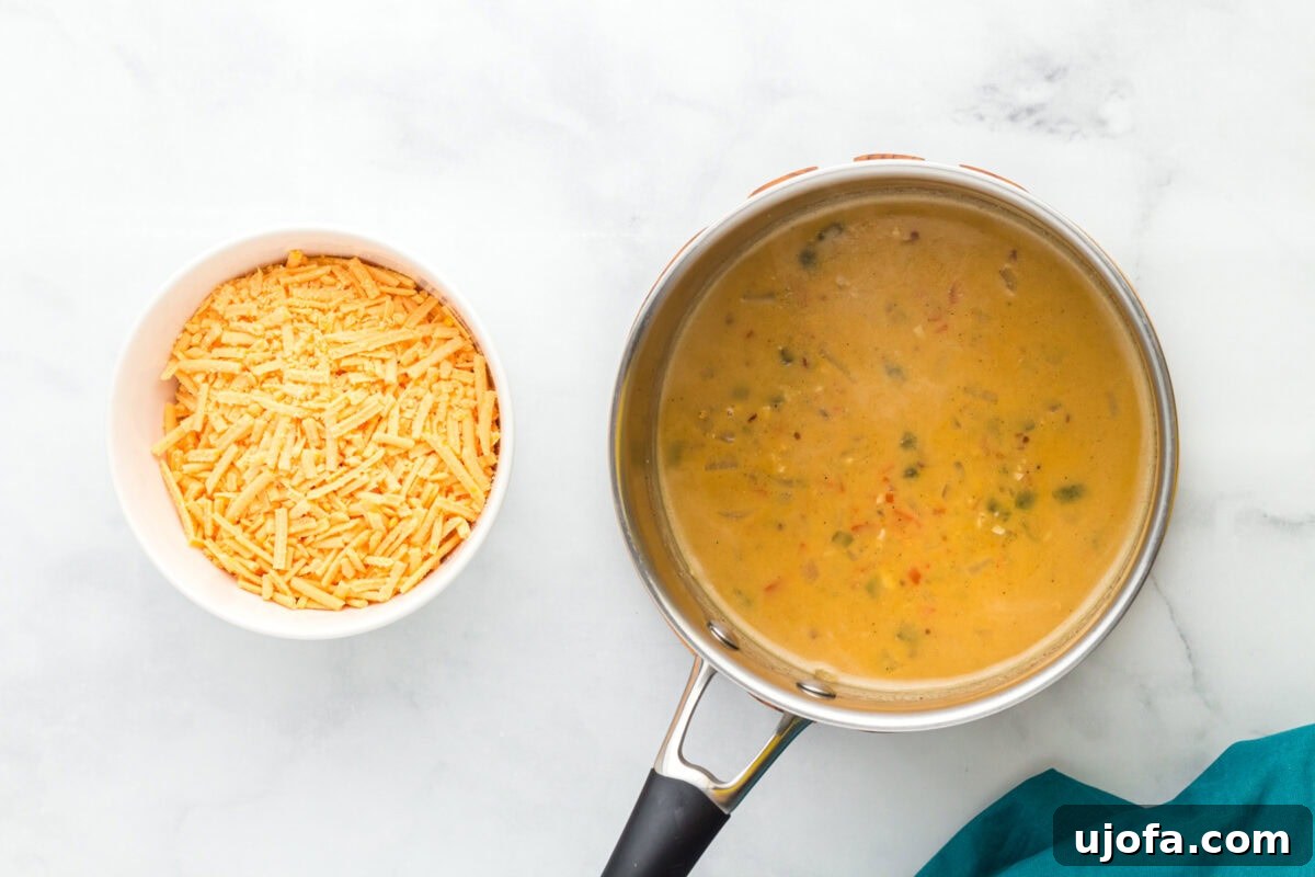 Creamy Vegan Queso 10 vegan cheese melting into queso mixture in stainless steel pot