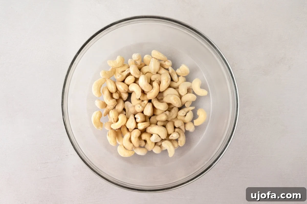 raw cashews soaking in water in a glass bowl
