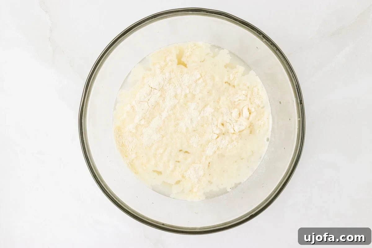 Crafting Perfect Arepas 5 Pre-cooked cornmeal on top of salt water in a glass bowl resting on a light surface.