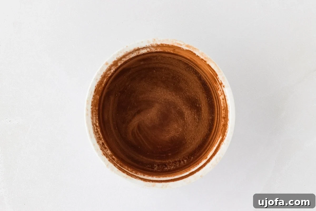 Molten Gluten Free Chocolate Bliss 5 A small white ramekin dusted with cocoa powder, ready for the batter.