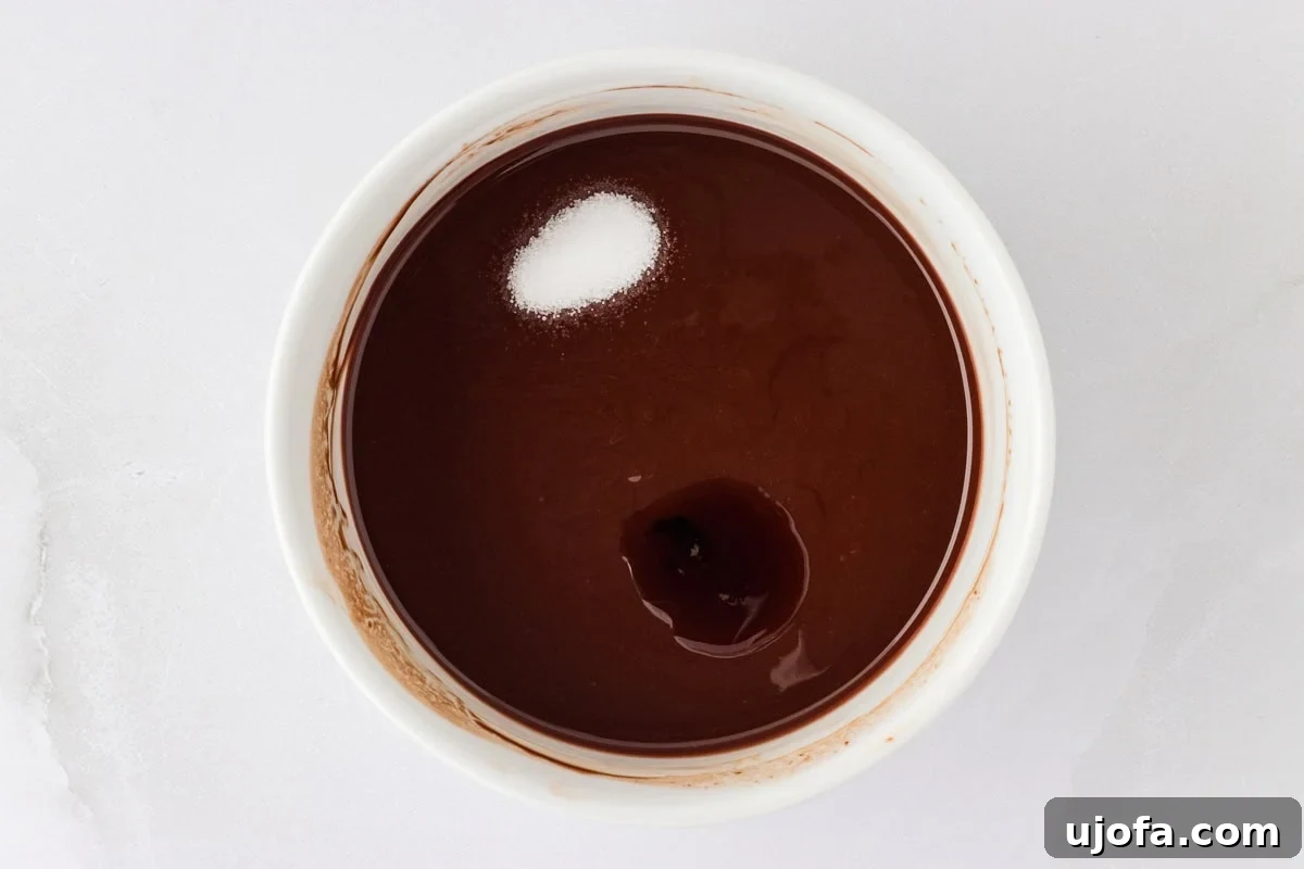 Molten Gluten Free Chocolate Bliss 7 Melted chocolate in a white ramekin with salt and vanilla extract added, ready to be stirred.