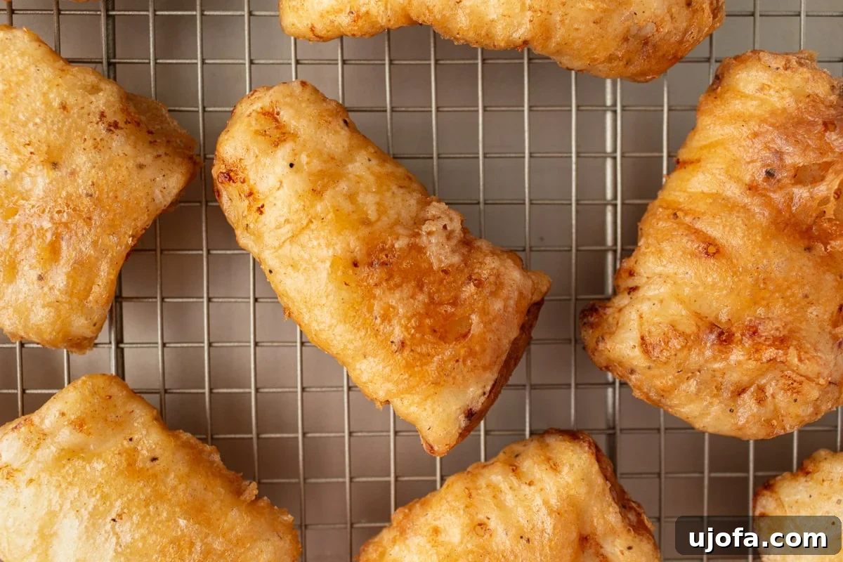 fried golden brown gluten-free fish resting on a wire rack