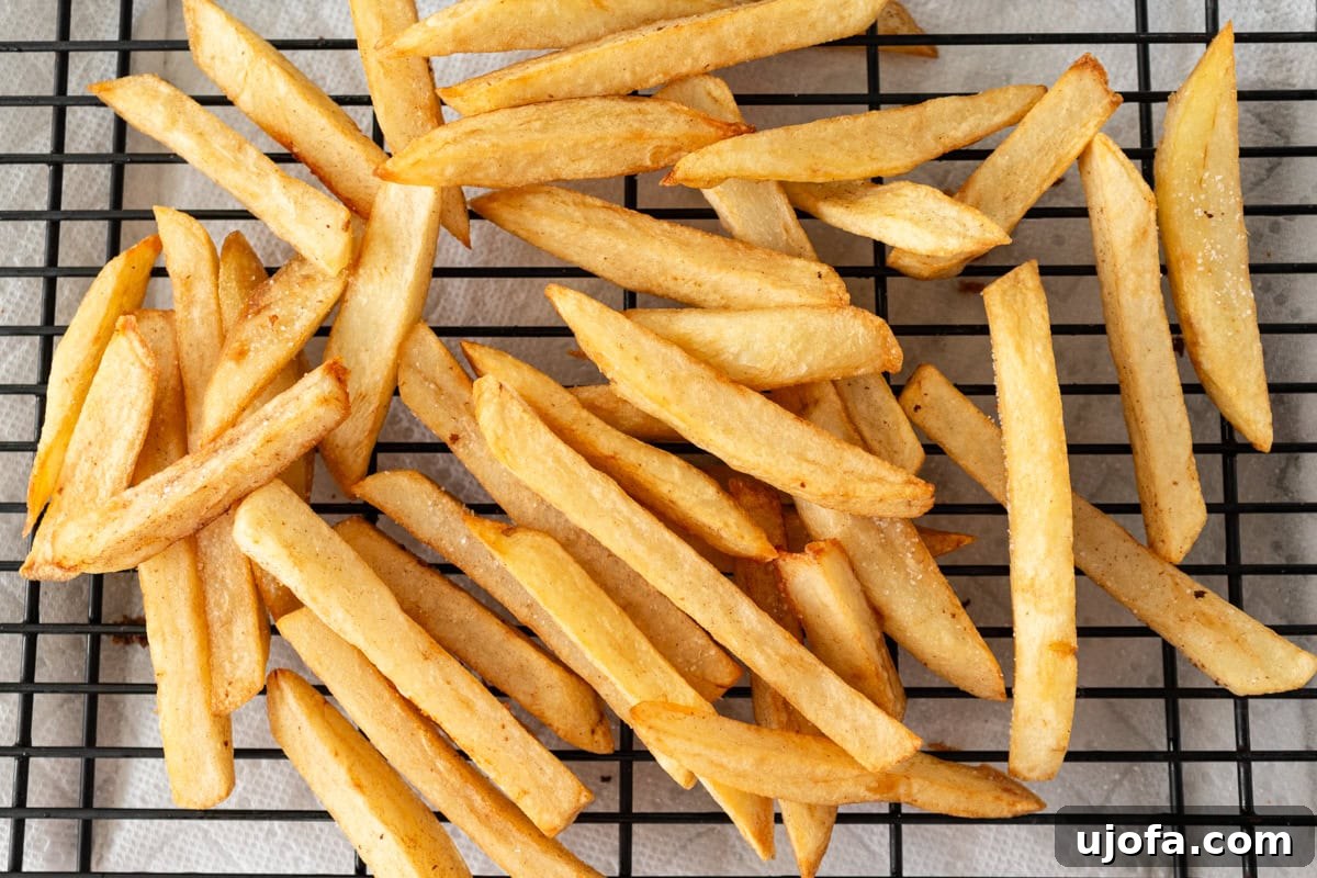 fried gluten-free French fries on a wire rack, golden and crispy