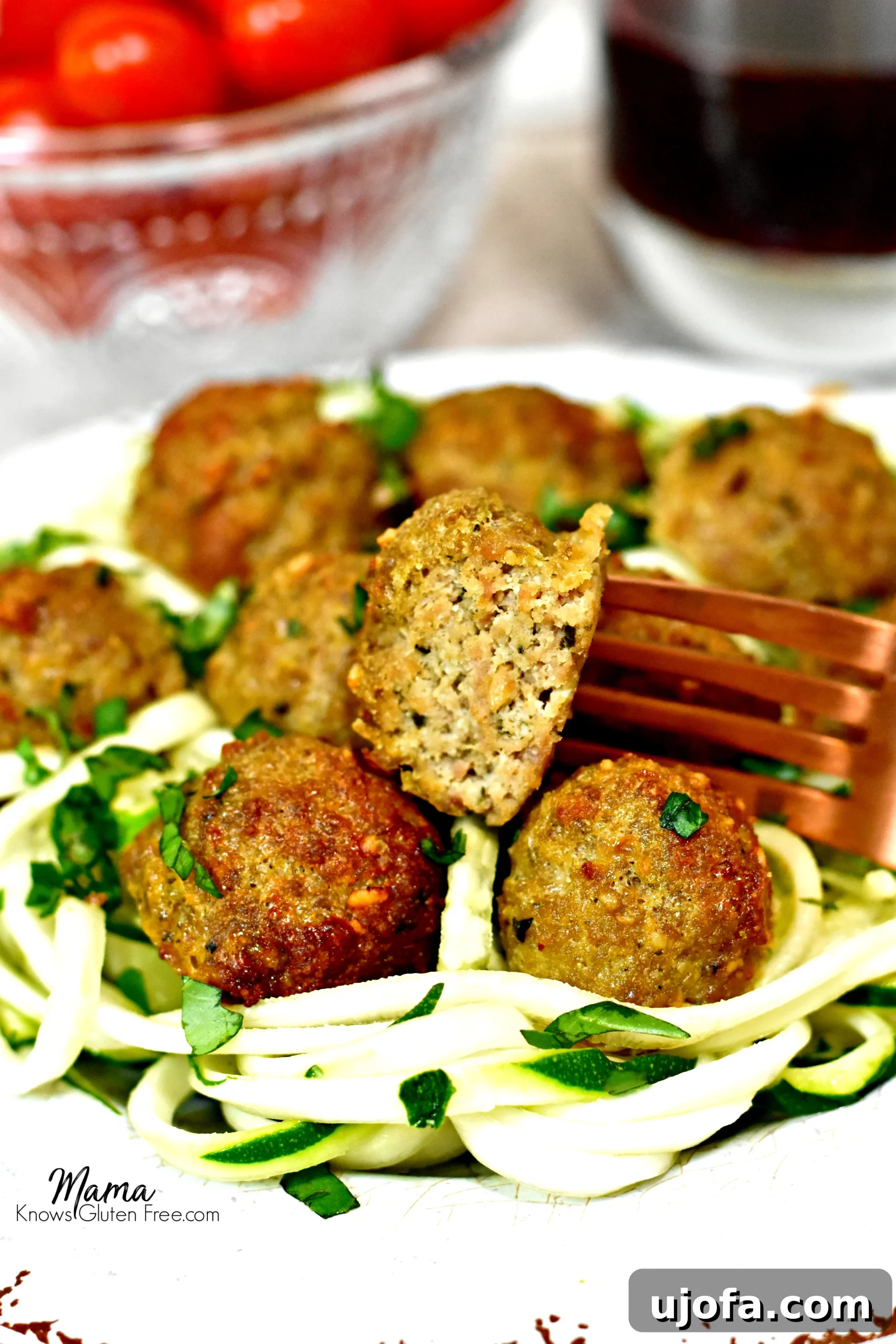 Close-up of a Paleo Pesto Turkey Meatball bite, showing the tender texture and vibrant green pesto