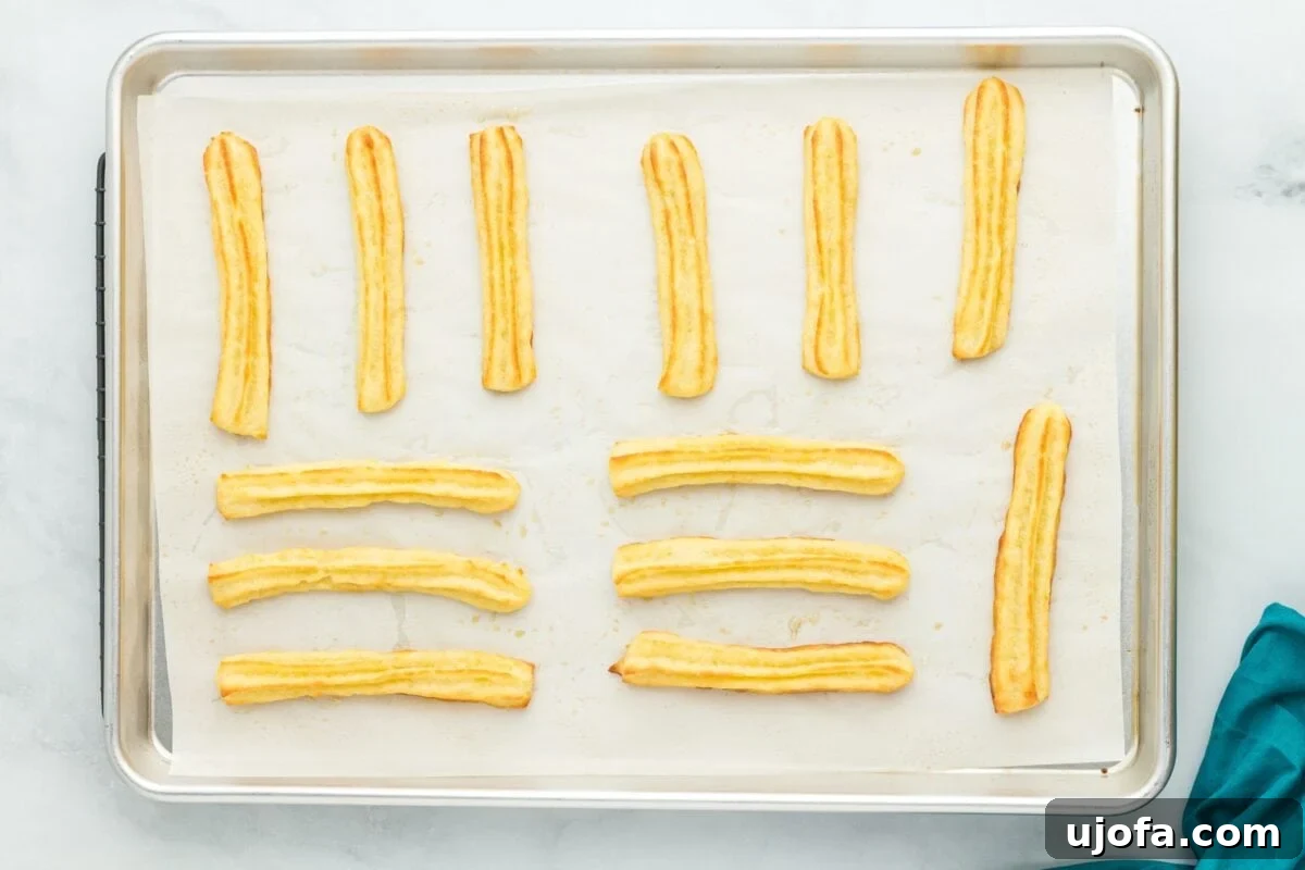 Delectable Gluten-Free Churros 9 A close-up of uncooked, piped gluten-free churros on a baking sheet, highlighting their distinct ridged pattern.