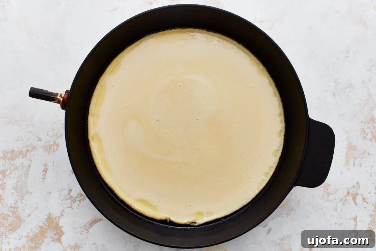 Savory Chickpea Flatbread 10 A cast iron skillet filled with uncooked chickpea flour batter.