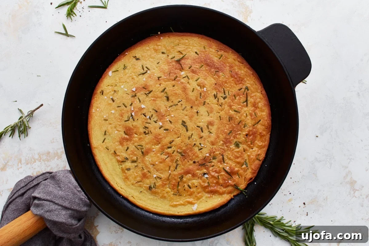 Savory Chickpea Flatbread 12 Freshly baked farinata in a skillet, garnished with rosemary and salt.