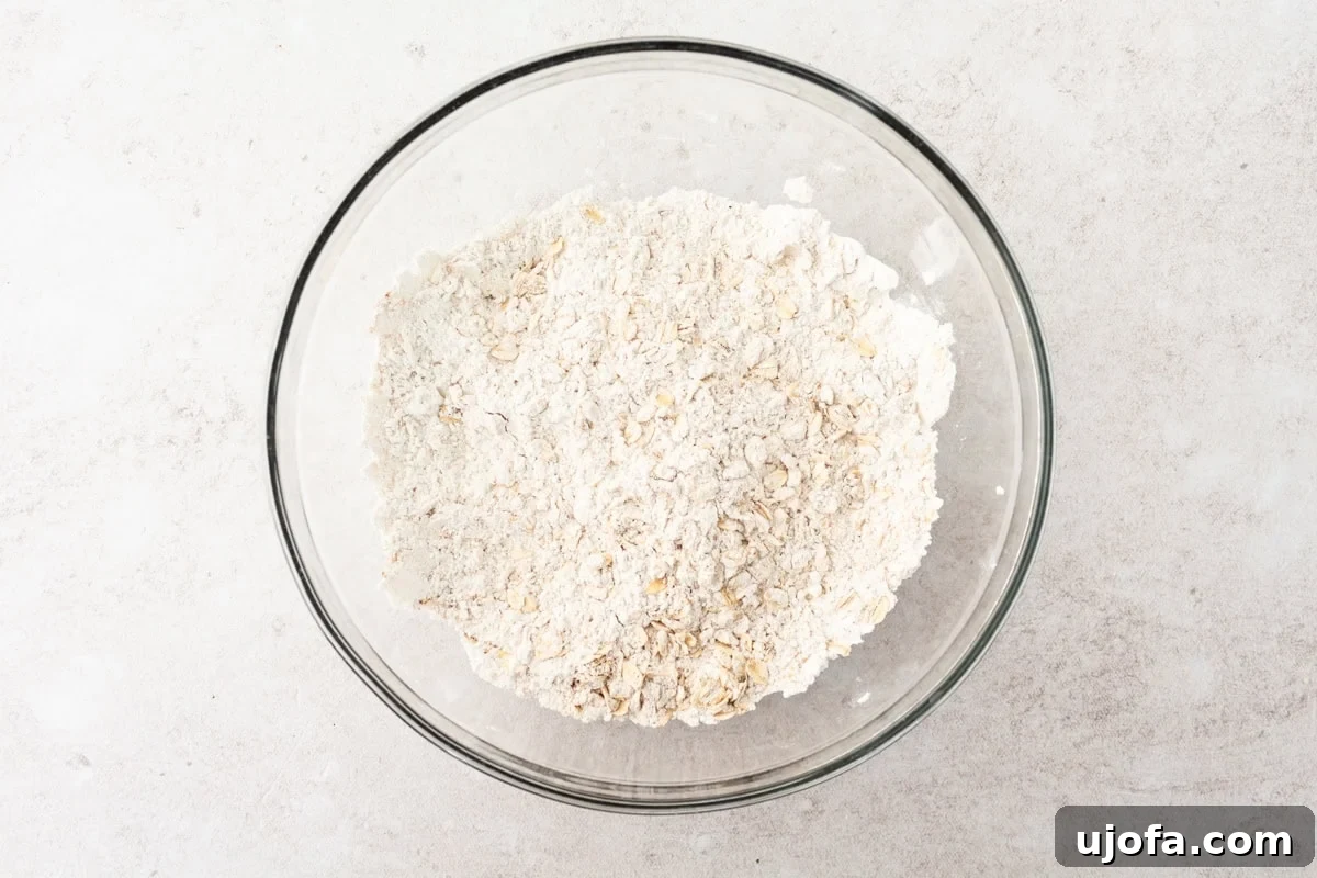A glass bowl containing a mixture of flour and oats for the muffin batter, before adding wet ingredients.