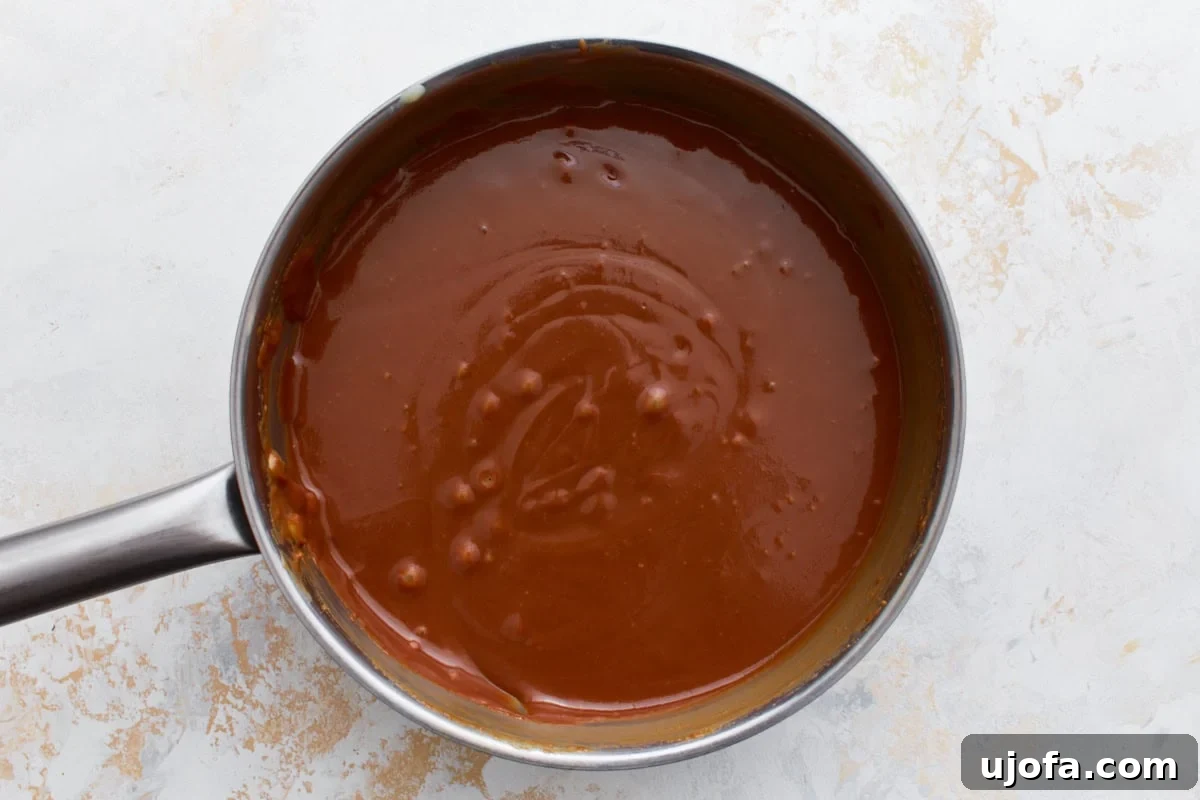 A saucepan filled with smooth, caramel-colored filling, freshly prepared and ready for layering.