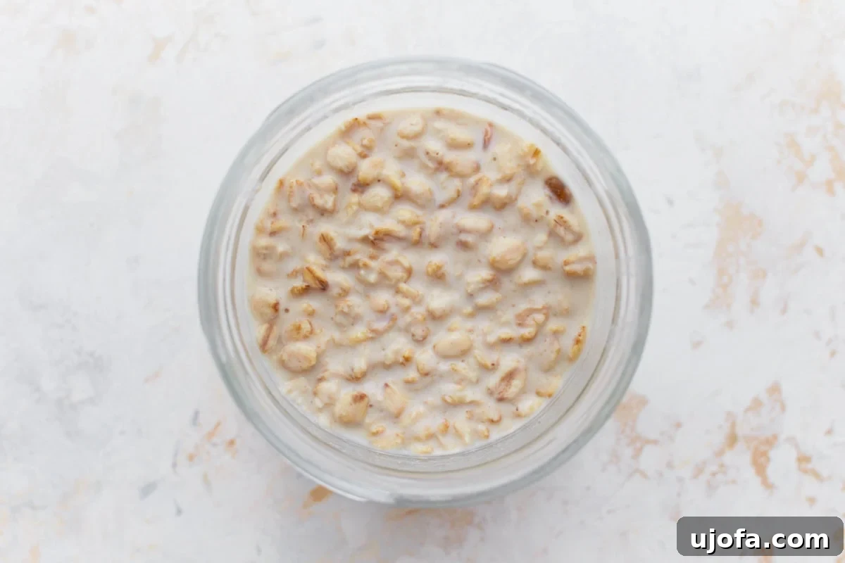 Gluten-Free Overnight Oats: Prep Today, Enjoy Tomorrow 6 A close-up of gluten-free overnight oats in a glass jar after being soaked, showing a creamy and slightly thickened texture.