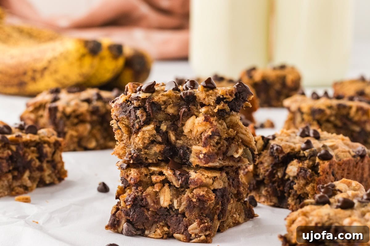 Golden Banana Oat Bars 15 Close-up of two stacked banana oatmeal bars with visible chocolate chips, oats,