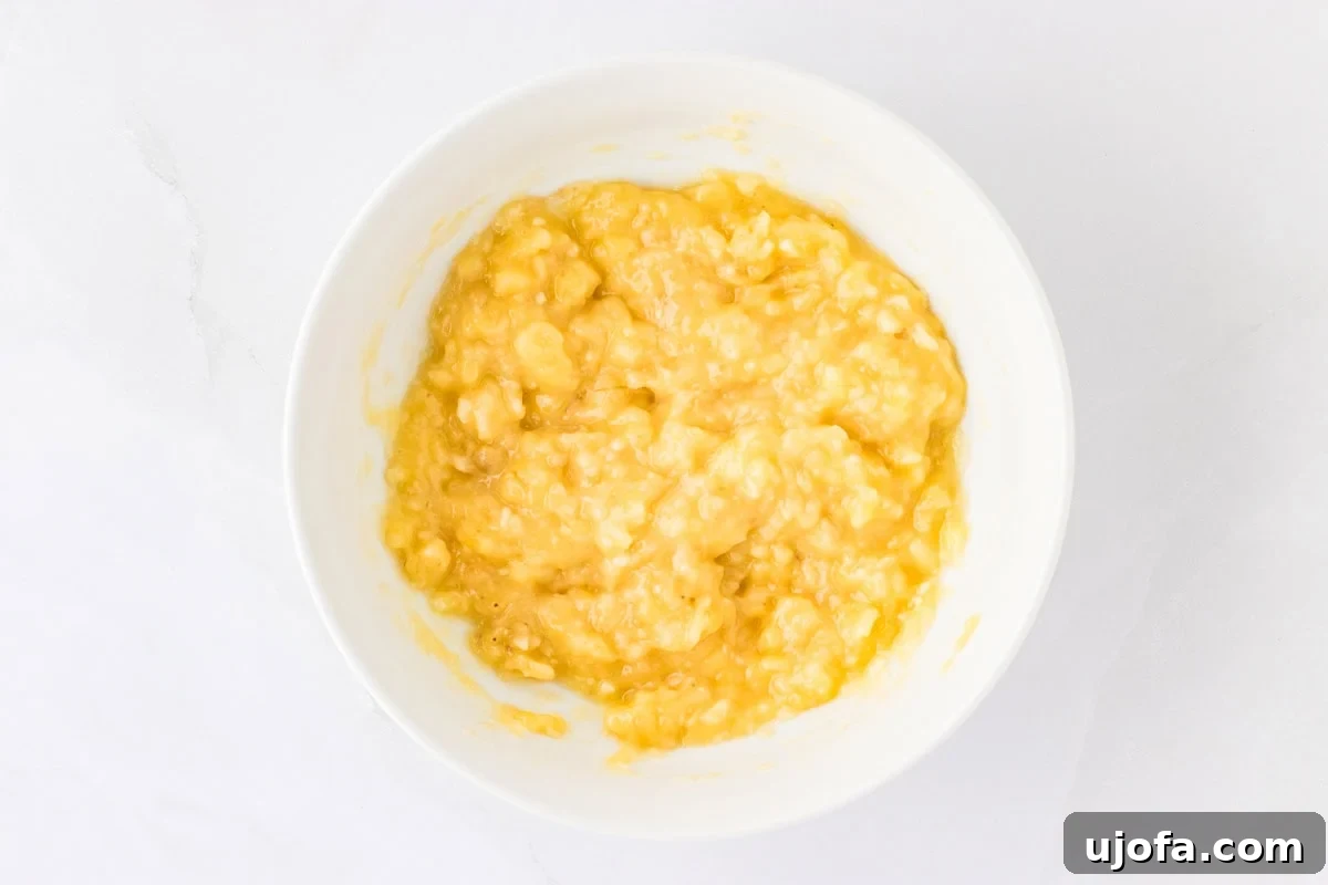Golden Banana Oat Bars 6 A bowl of mashed ripe bananas with a smooth texture, ready to be used in the recipe.
