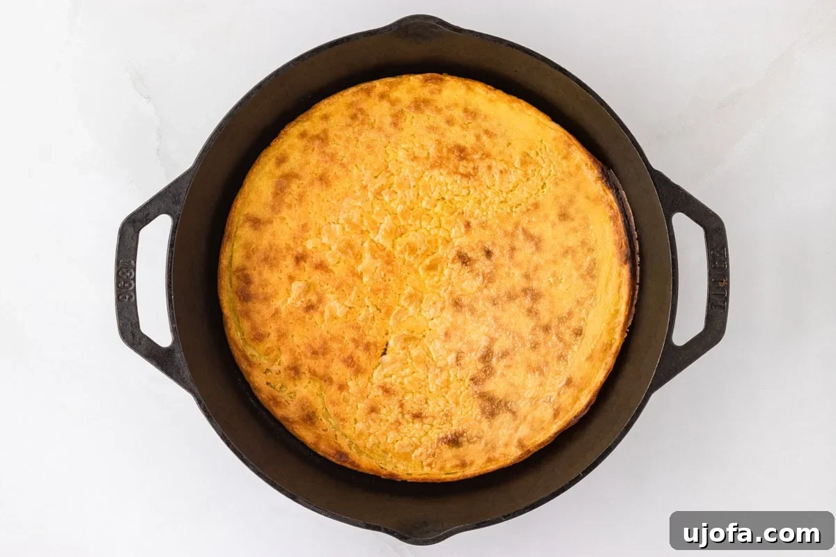 Golden Socca Chickpea Flatbread 11 A freshly baked socca flatbread with a golden crust, resting in a cast iron skillet.