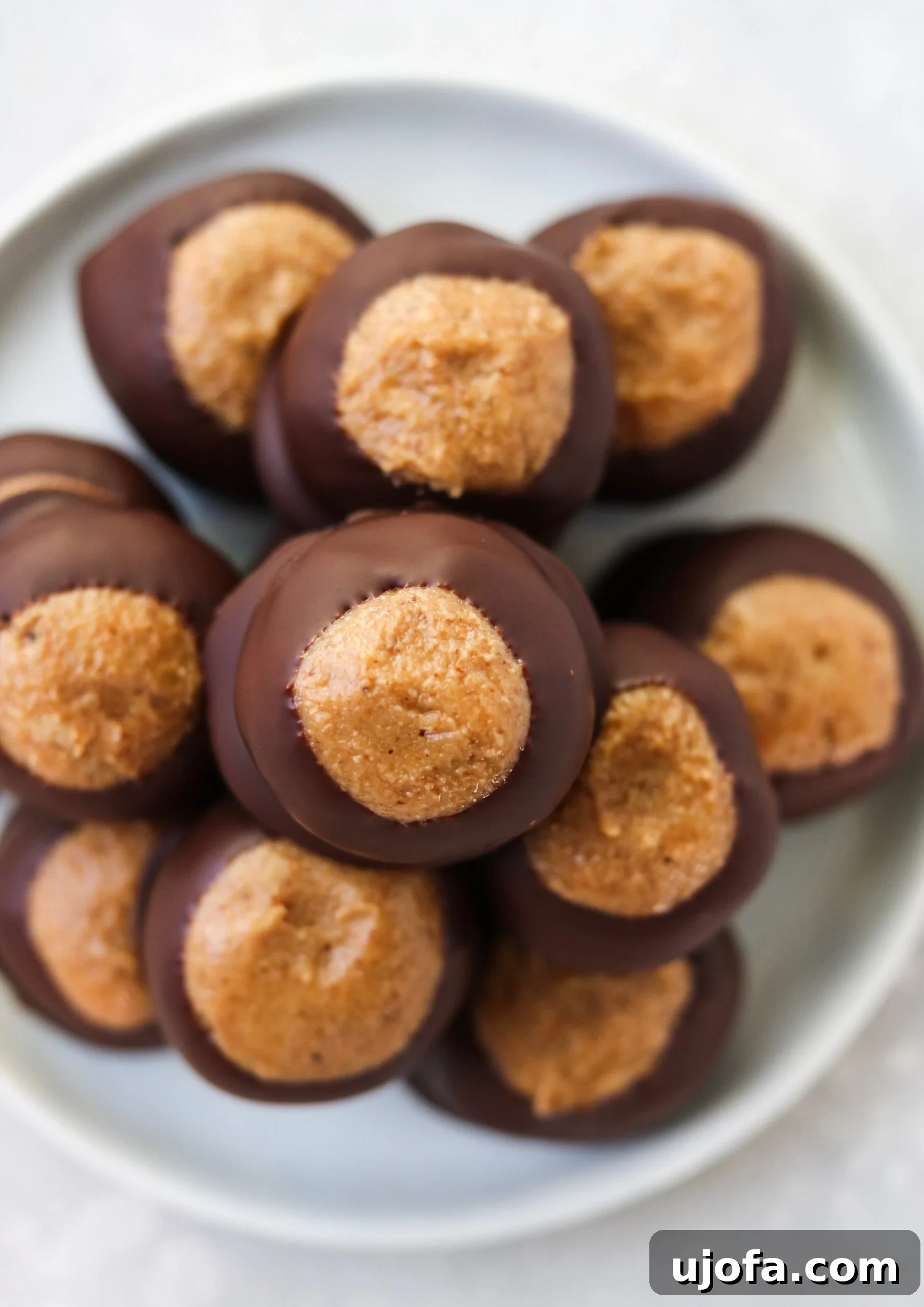 A tray of freshly dipped Paleo Buckeye Balls, waiting for their chocolate coating to set in the refrigerator.
