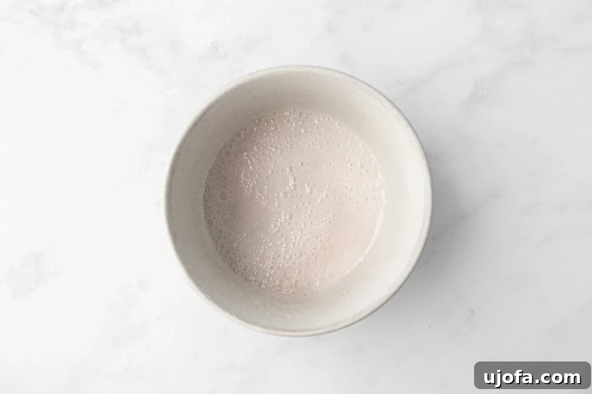 A small bowl with a frothy baking soda and vinegar mixture, which helps the cupcakes rise.