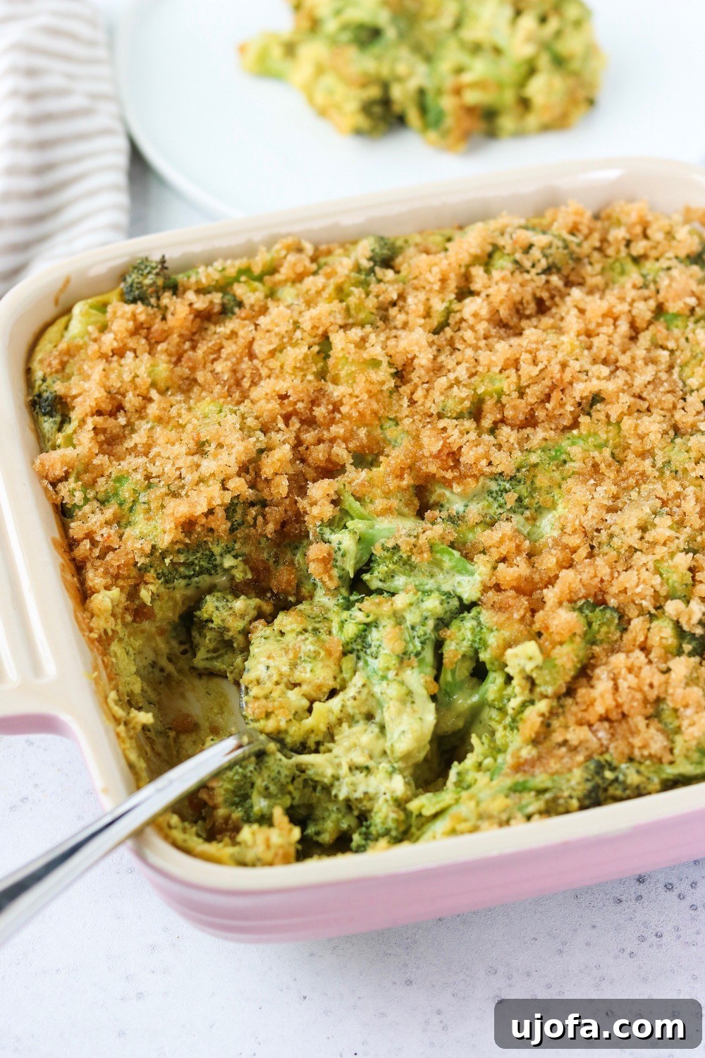 Muhteşem Paleo Şükran Günü Sofrası İçin Her Şey 11 A golden-brown Dairy-Free 'Cheesy' Broccoli Casserole, bubbly and warm in a ceramic baking dish, showing tender broccoli florets enveloped in a creamy, savory sauce.