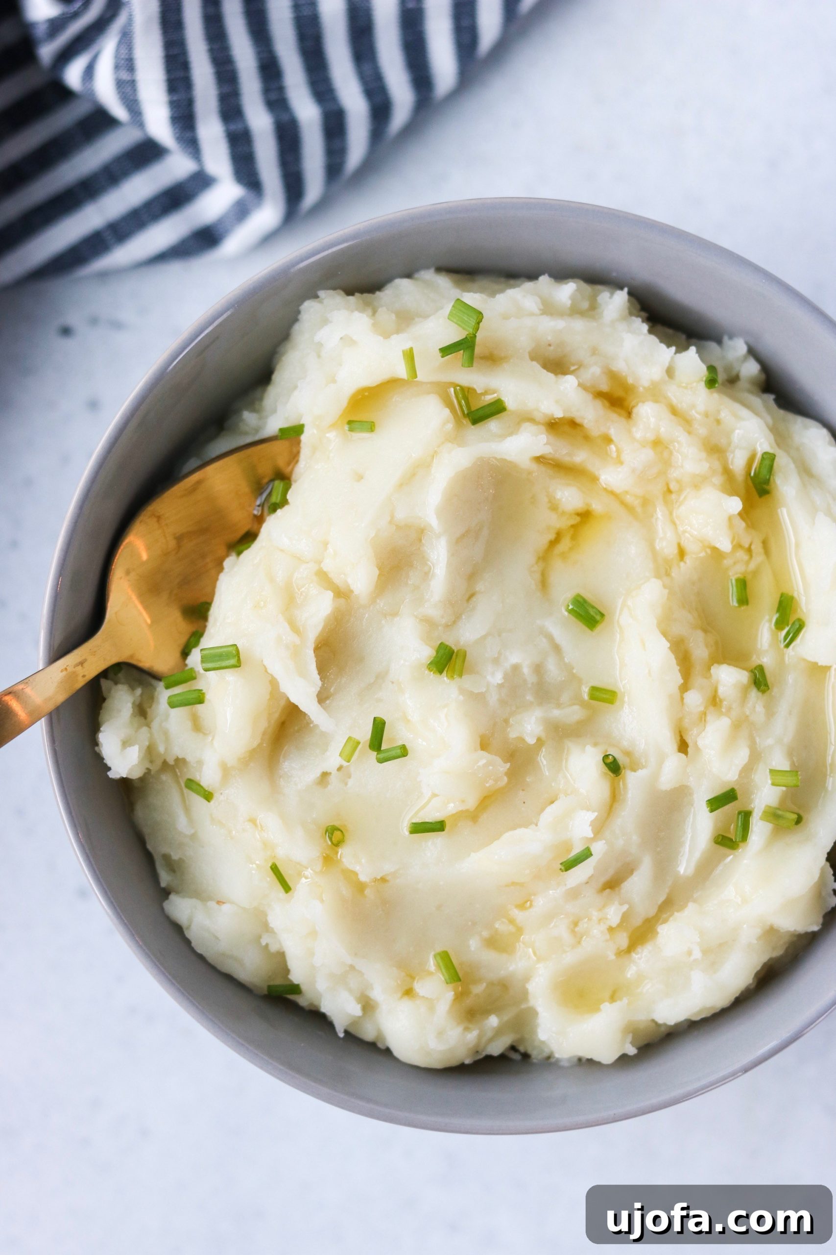 Muhteşem Paleo Şükran Günü Sofrası İçin Her Şey 3 A close-up shot of incredibly creamy, fluffy mashed potatoes in a white serving bowl, garnished with fresh herbs and a drizzle of melted ghee, inviting viewers to savor its rich texture.