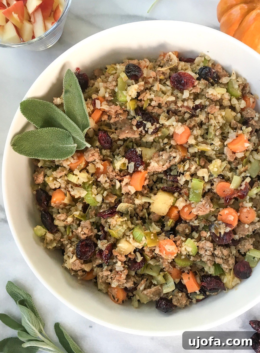 Muhteşem Paleo Şükran Günü Sofrası İçin Her Şey 6 A close-up of a savory Cauliflower Rice and Sausage Stuffing, richly colored with herbs, sausage pieces, and finely chopped vegetables, served in a rustic bowl.