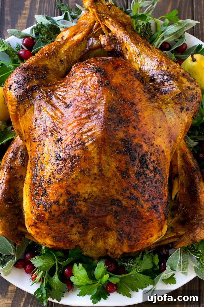 Muhteşem Paleo Şükran Günü Sofrası İçin Her Şey 7 A perfectly golden-brown roasted turkey, beautifully carved and presented on a large platter, garnished with fresh herbs and citrus, ready to be served as the centerpiece of a holiday meal.