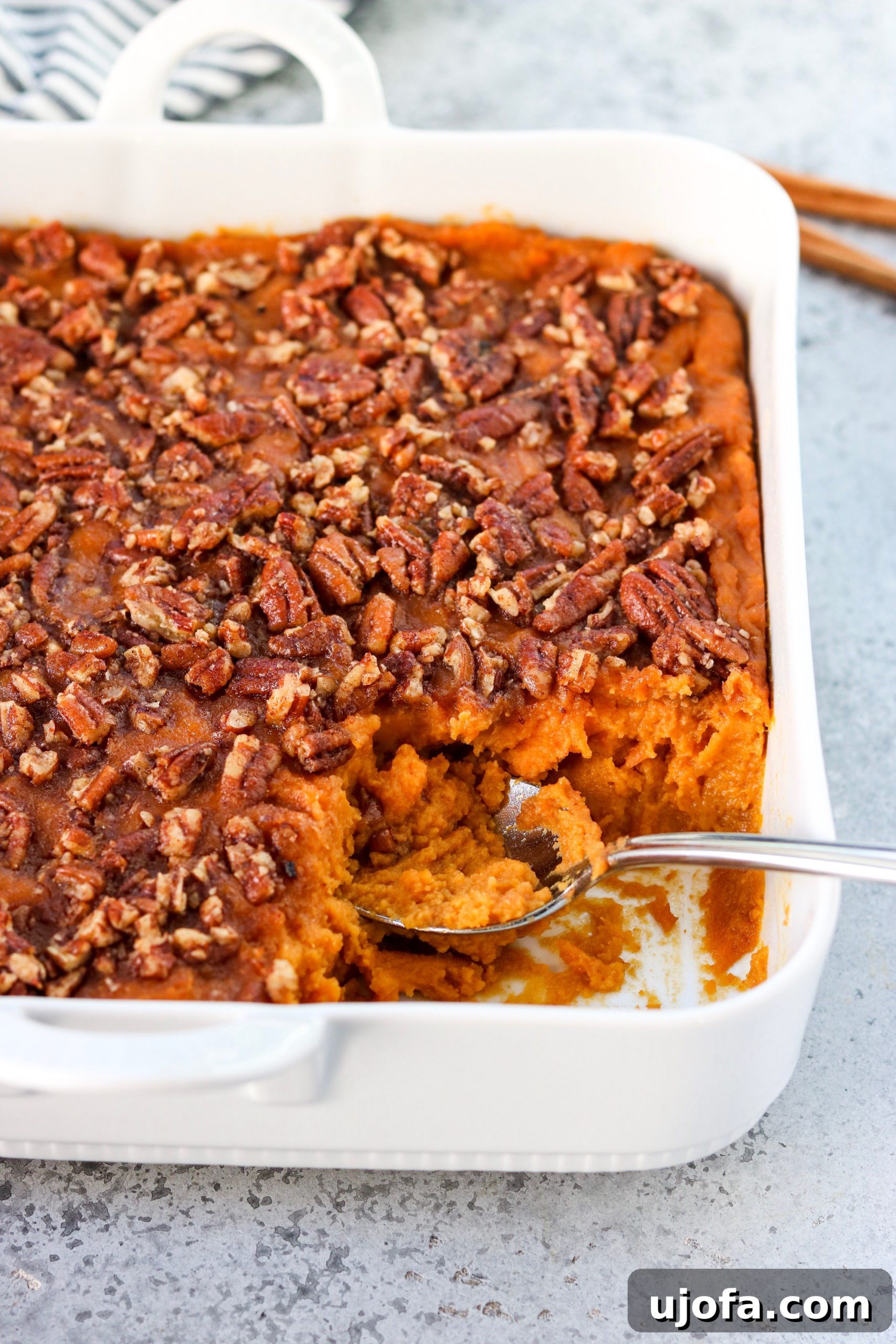 Muhteşem Paleo Şükran Günü Sofrası İçin Her Şey 10 A rich and creamy Paleo Sweet Potato Casserole in a baking dish, topped with a crunchy nut and pecan crumble, ready to be served, highlighting its comforting appeal.