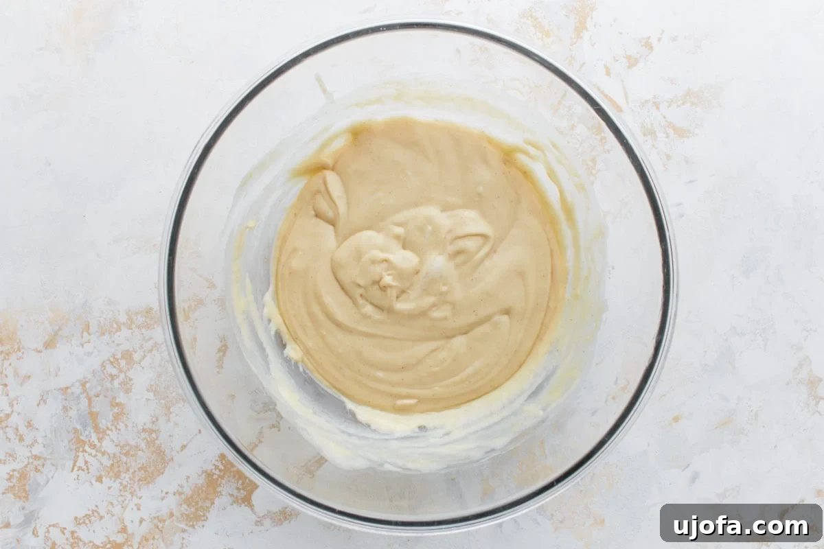 Gluten-Free Cinnamon Swirl Delights 6 Fully mixed cinnamon roll muffin batter in a glass bowl, smooth and creamy in texture.