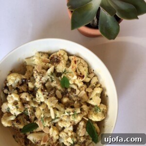 Vibrant roasted cauliflower with tahini sauce, herbs, and almonds.