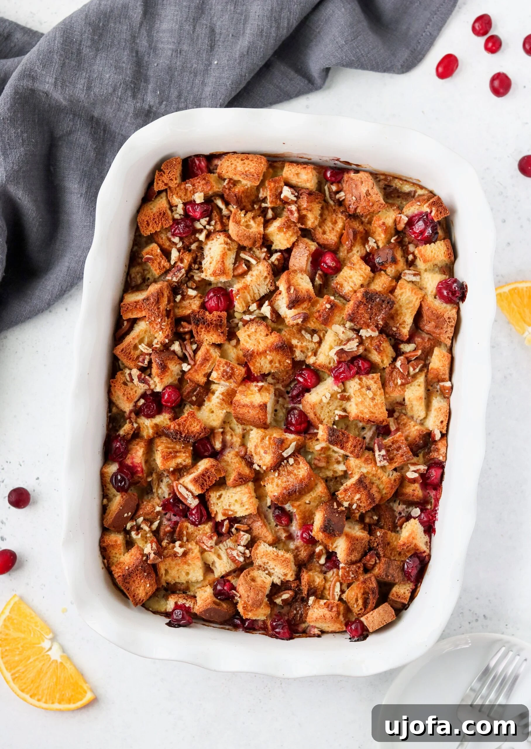 Close-up of Orange Cranberry Overnight French Toast Casserole, showcasing the fluffy bread soaked in custard, studded with vibrant cranberries.