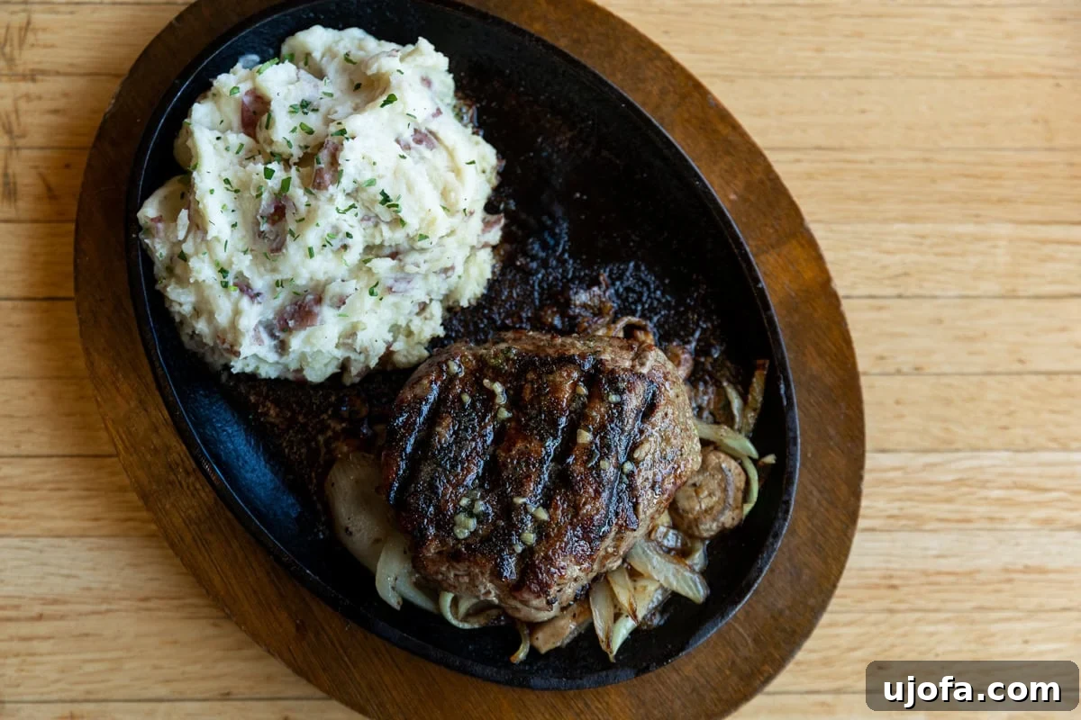 Applebees Gluten Free Dining 4 A sizzling Bourbon Street Steak from Applebee's, perfectly cooked and served with a side of creamy mashed potatoes, showcasing a delicious gluten-free entree option.