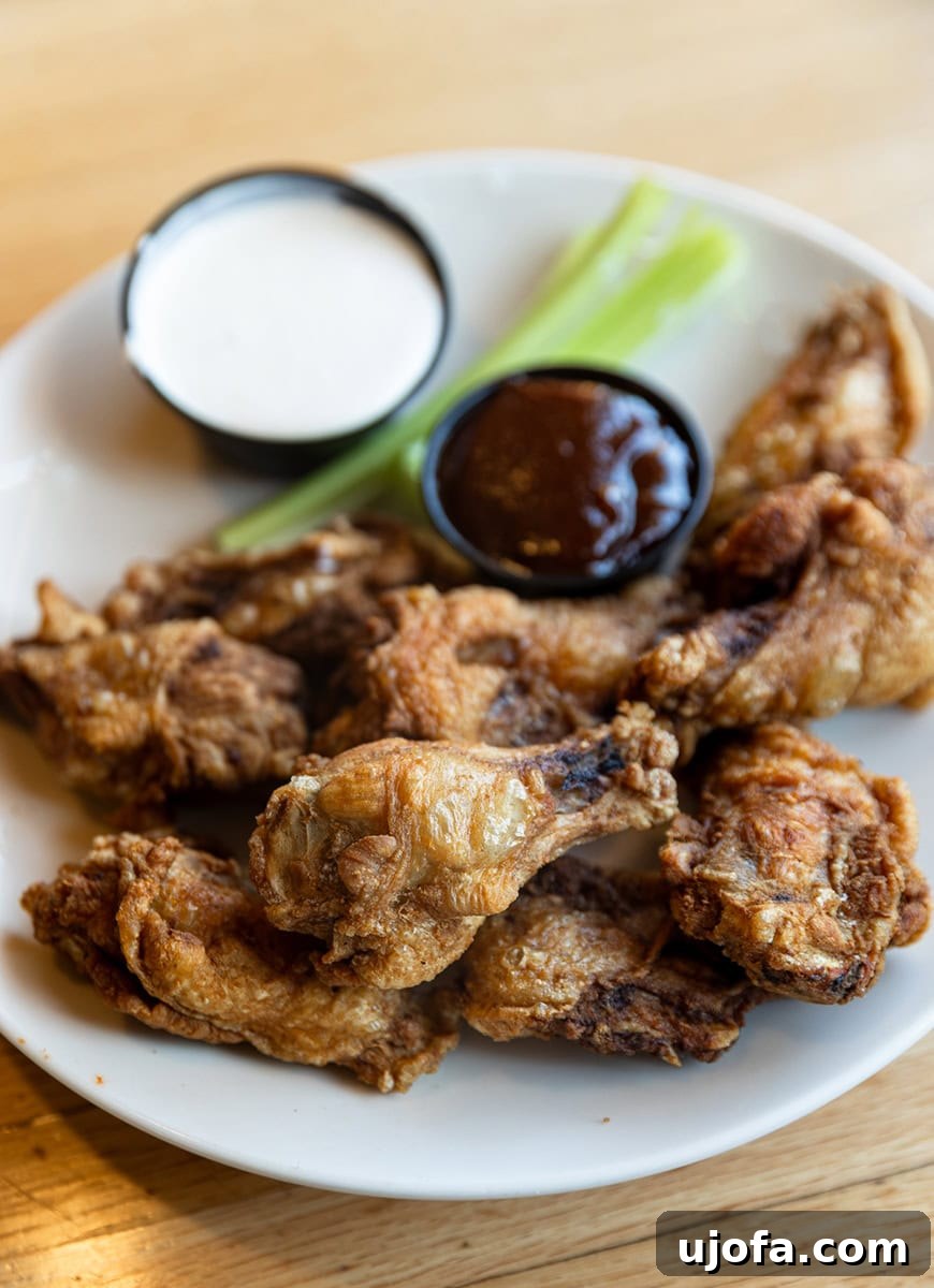Applebees Gluten Free Dining 6 An appetizing close-up of gluten-free classic bone-in wings from Applebee's, accompanied by an array of gluten-free dipping sauces, highlighting safe and delicious choices.