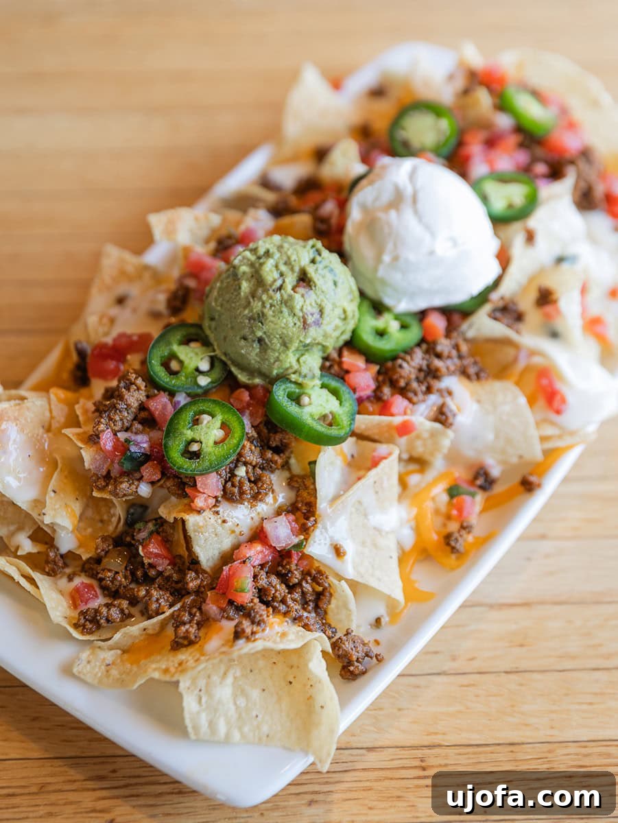 Applebees Gluten Free Dining 7 A generously portioned plate of gluten-free Neighborhood Nachos from Applebee's, piled high with cheese, toppings, and your choice of protein, a perfect appetizer for sharing.