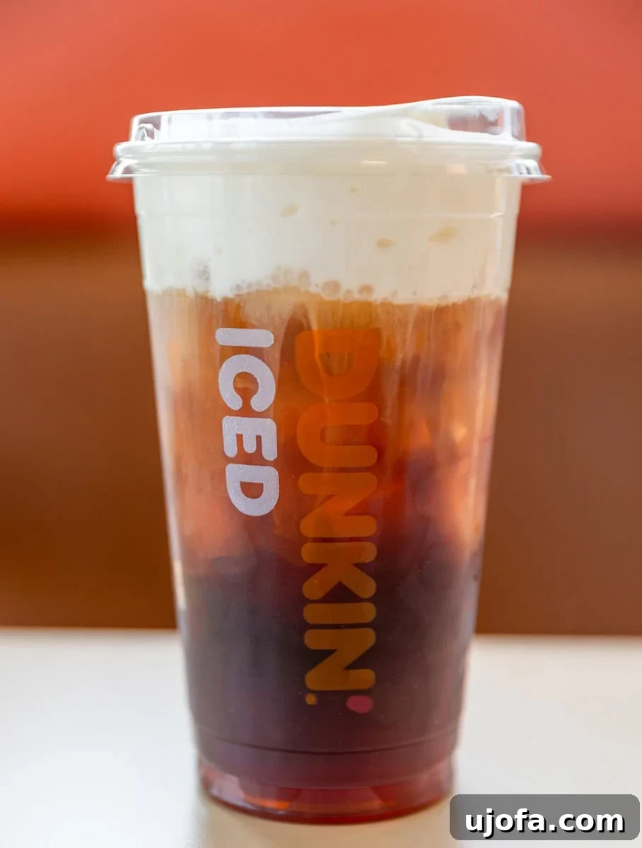 Cold brew coffee with foam, a popular gluten-free choice at Dunkin' Donuts.