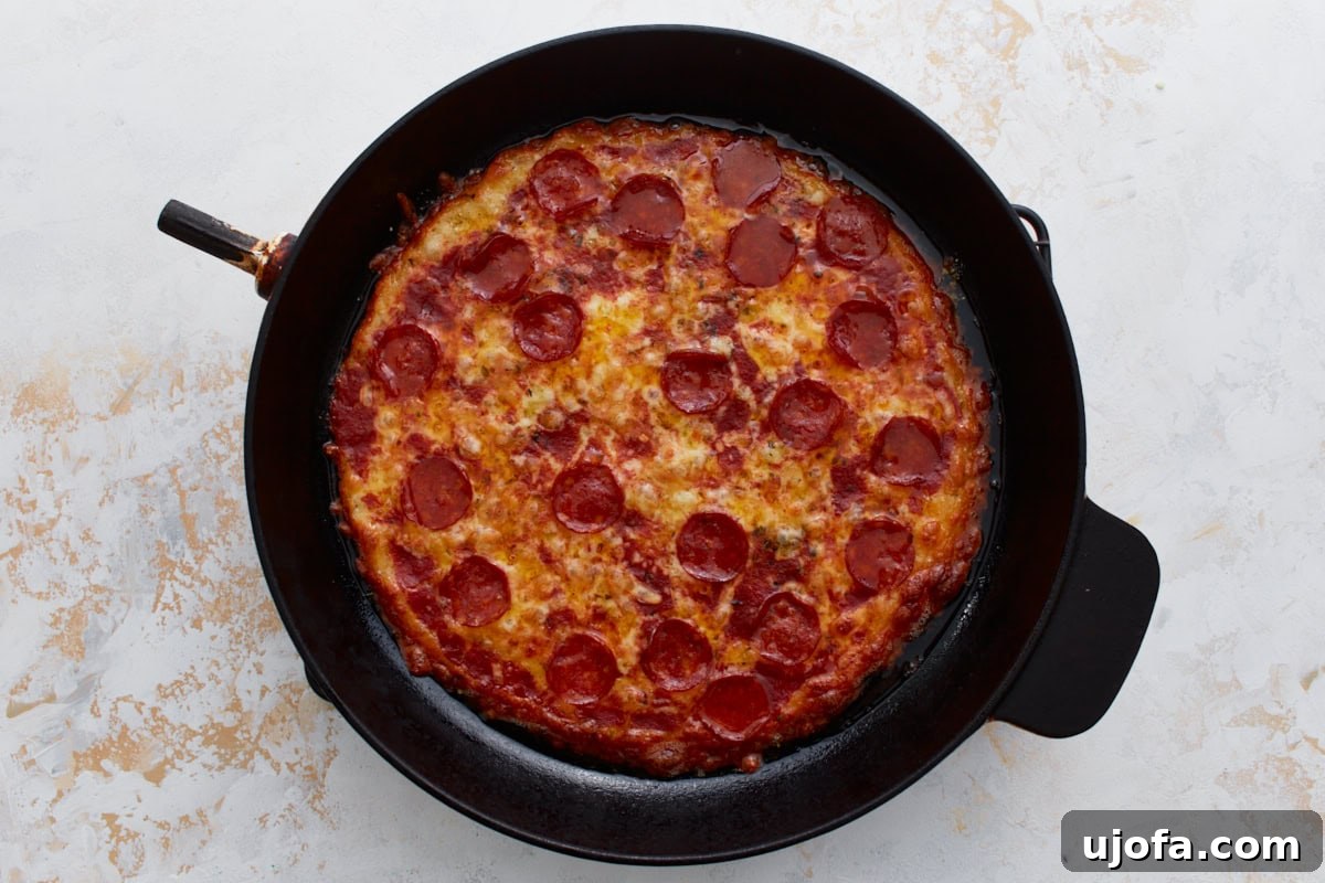 Pizza Bowl 9 The crustless pepperoni pizza, fully baked with a golden-brown and bubbling cheese top, resting in the cast iron skillet just out of the oven.